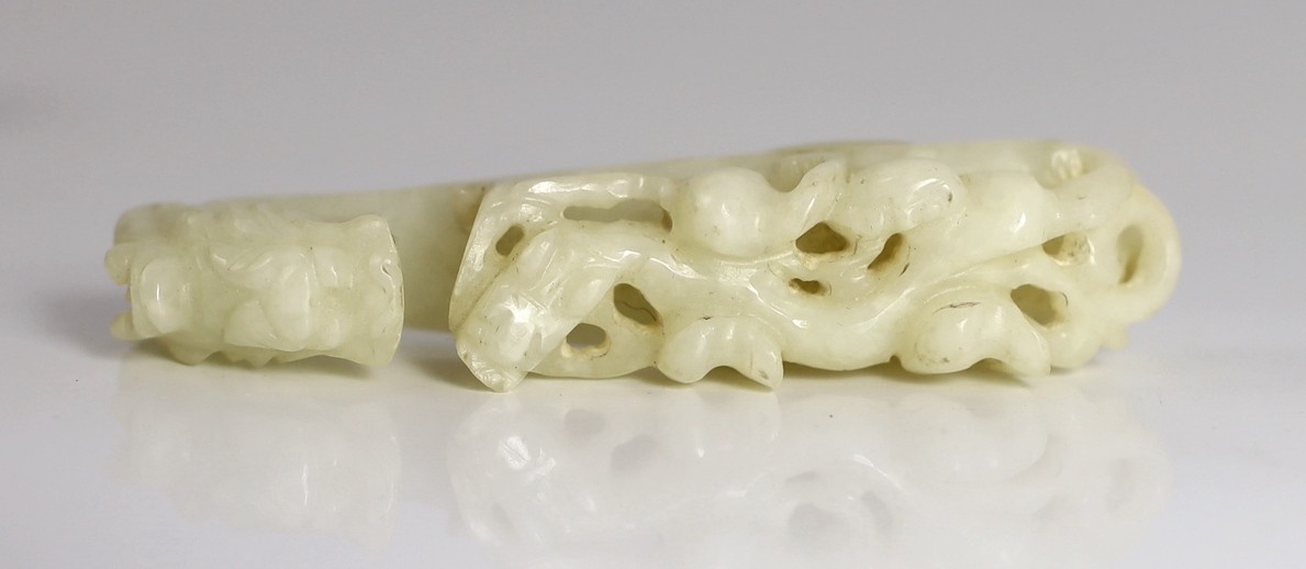 A Chinese white jade ‘dragon’ belt hook, 19th century, 9.4cm long, wood stand